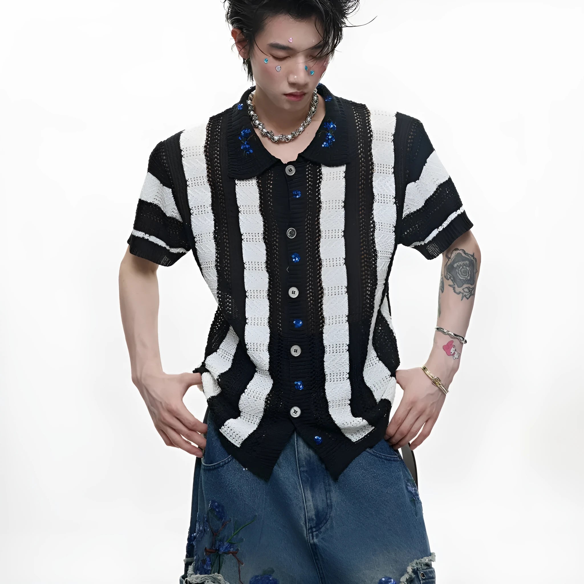 Man wearing a red and black patchwork striped retro knitted short-sleeved shirt in a loose fit.