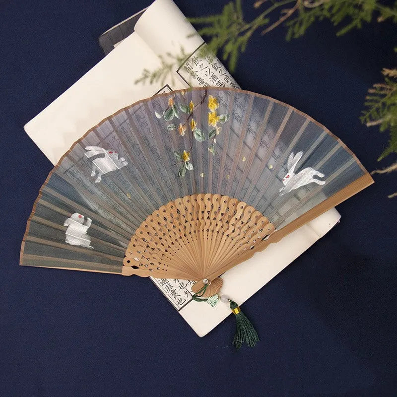 Bamboo frame silk embroidered folding fan showing intricate traditional patterns with folded and open positions