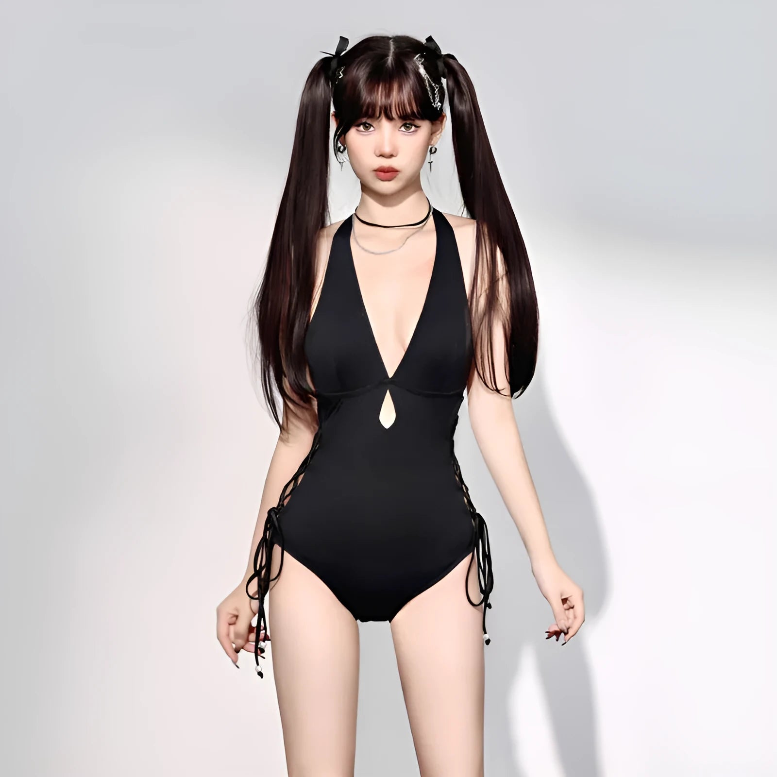Black women's one-piece swimsuit with V-neckline and hollow strap design on mannequin