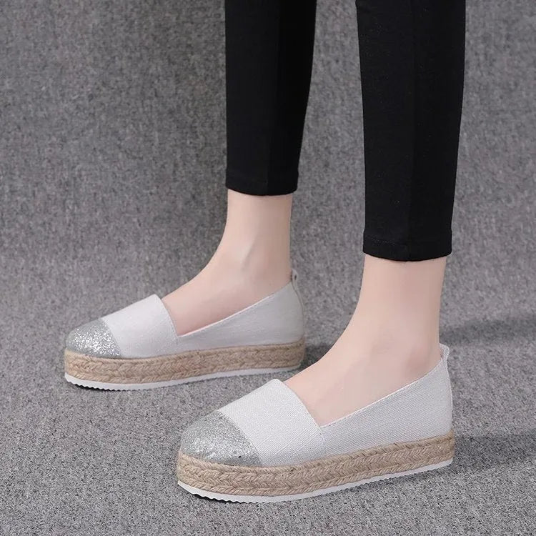 Women's plus size black canvas slip-on flat shoes with round toe, shown from the side.