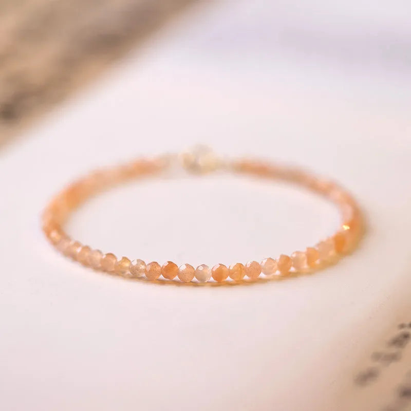 Close-up of a women's bracelet with small 3mm sunstone crystal beads on a wrist, showing its thin profile.