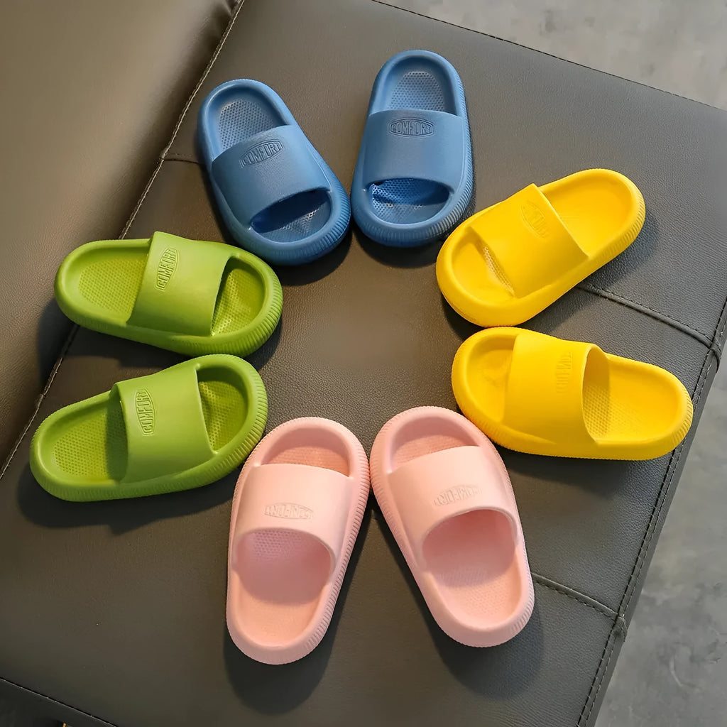 Colourful children's EVA slippers with a textured non-slip sole, shown in blue, green, orange, pink and yellow.