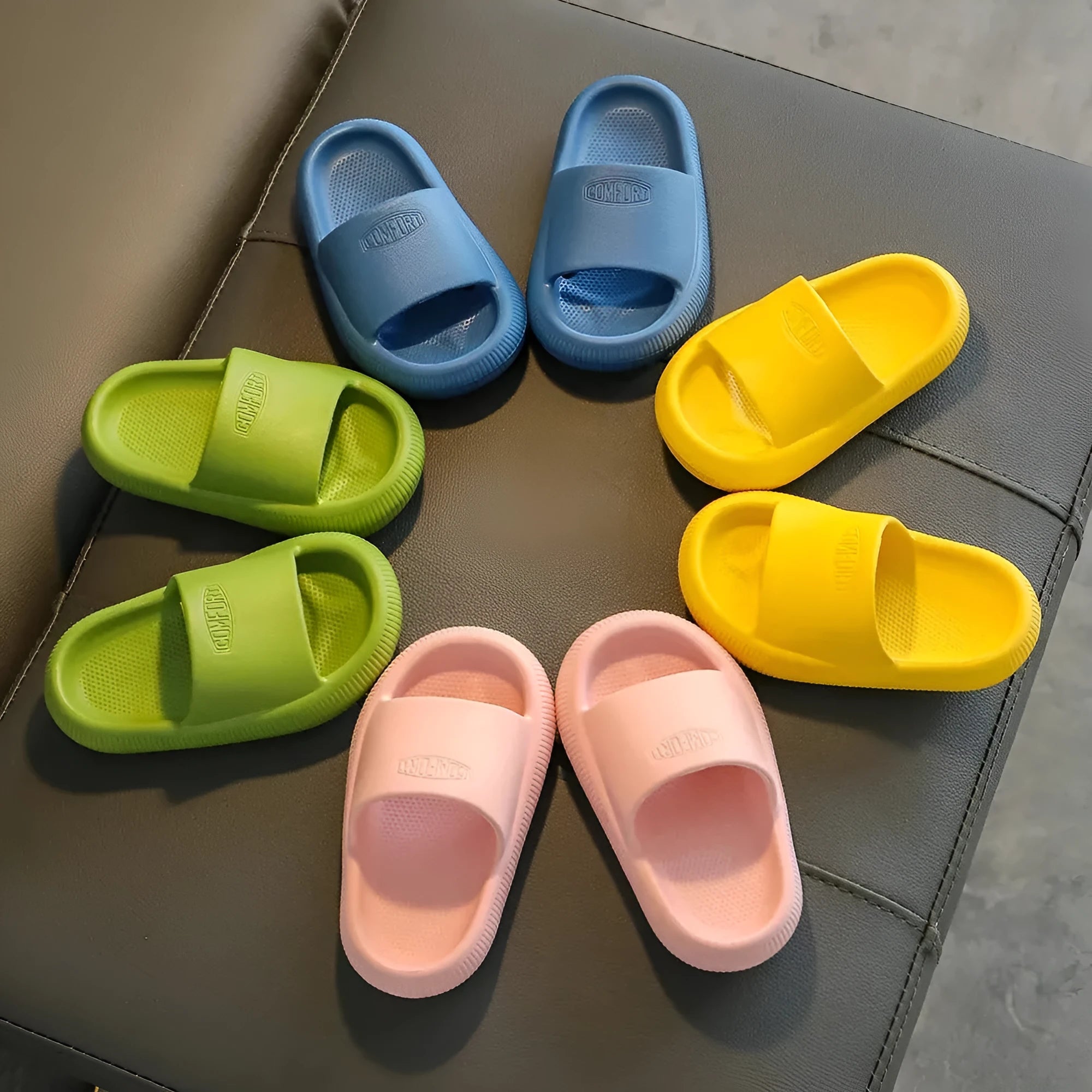 Colourful children's EVA slippers with a textured non-slip sole, shown in blue, green, orange, pink and yellow.