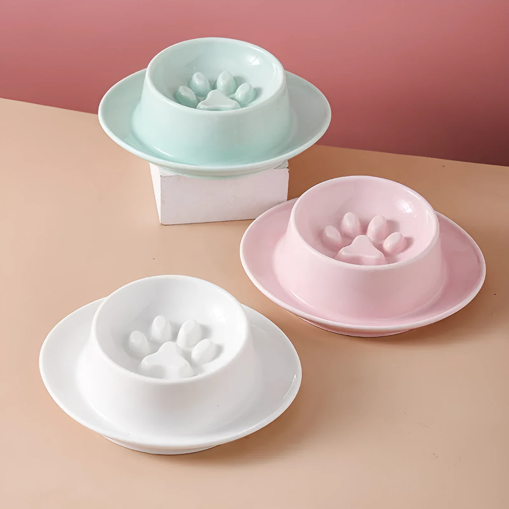 Green ceramic slow feed pet bowl with internal ridges and a raised centre on a white surface.