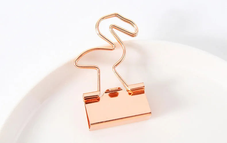 Small gold-plated metal office clip with a long tail, shown in a choice of flamingo, love, clouds, cat, and cactus shapes.