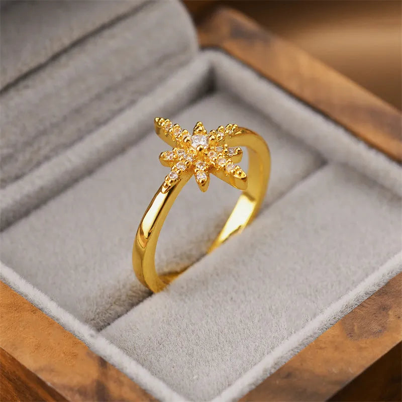 Gold electroplated geometric women's ring with an open adjustable design on a plain background