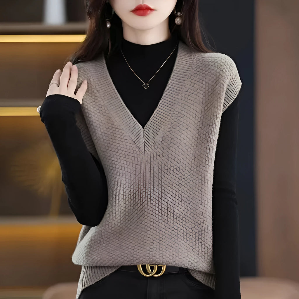 Women's beige sleeveless V-neck knitted vest with a 3D pattern texture on a hanger.
