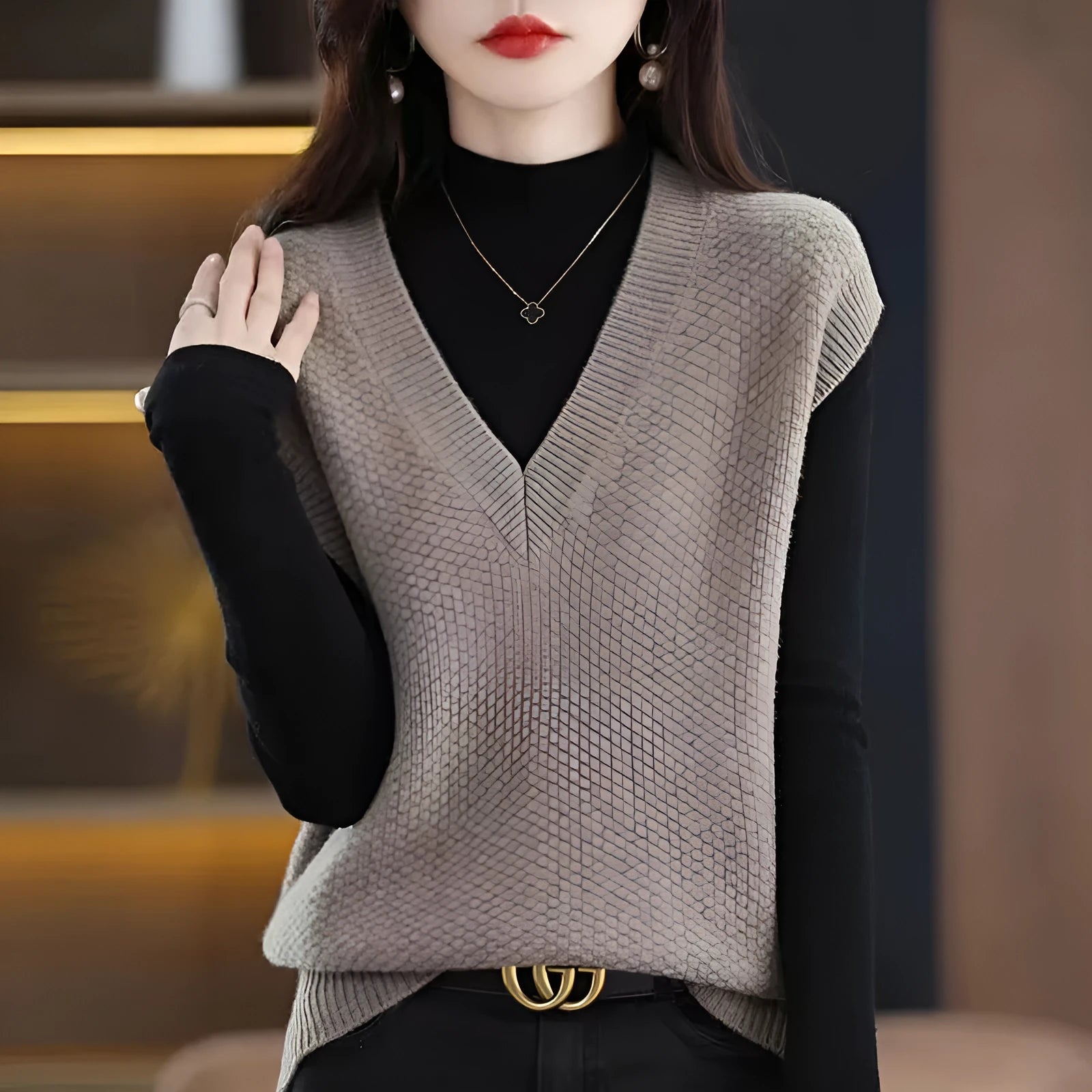 Women's beige sleeveless V-neck knitted vest with a 3D pattern texture on a hanger.