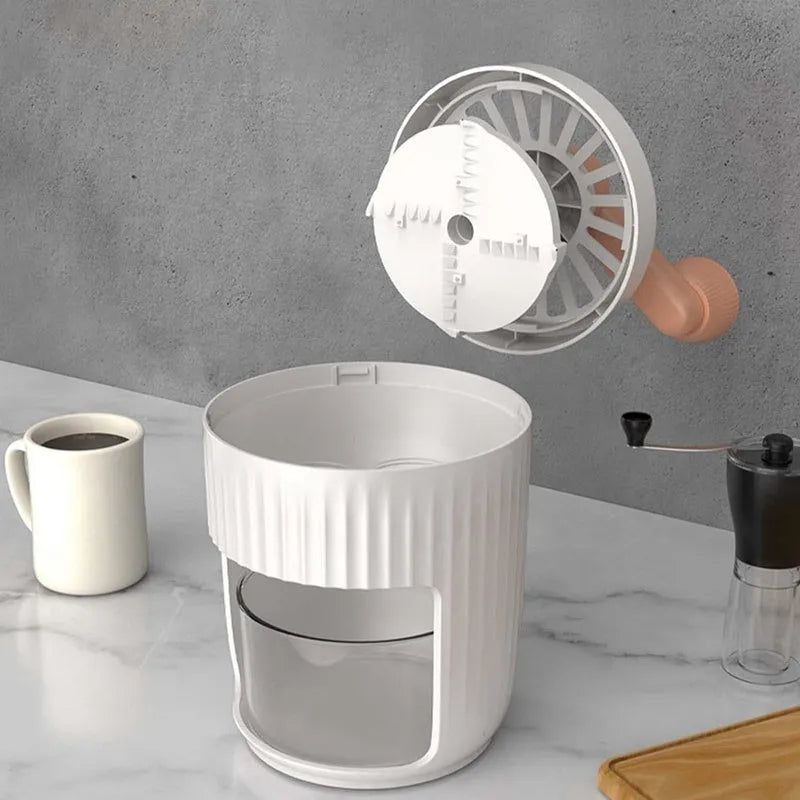 Hand-cranked ice shaving machine in green and orange, compact portable snow cone maker with ergonomic handle and removable ice box.
