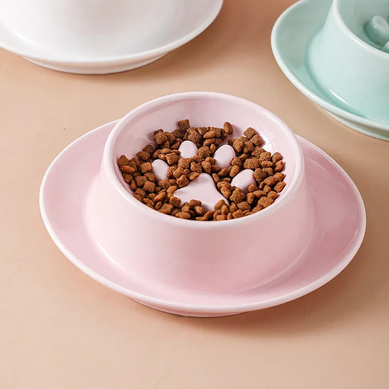Green ceramic slow feed pet bowl with internal ridges and a raised centre on a white surface.