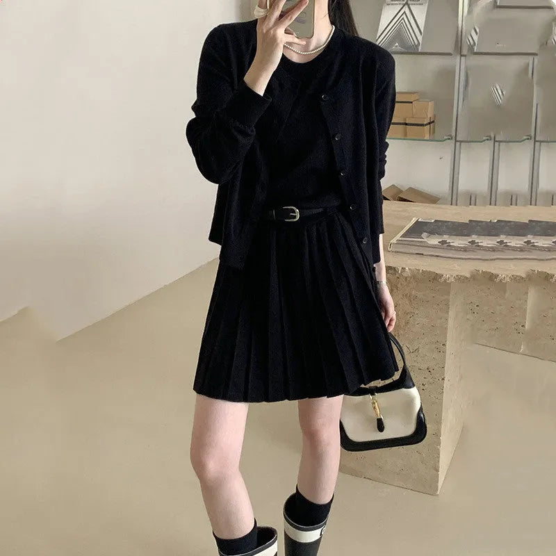 Grey knitted women's two-piece set with a pleated vest skirt and long-sleeved cardigan.