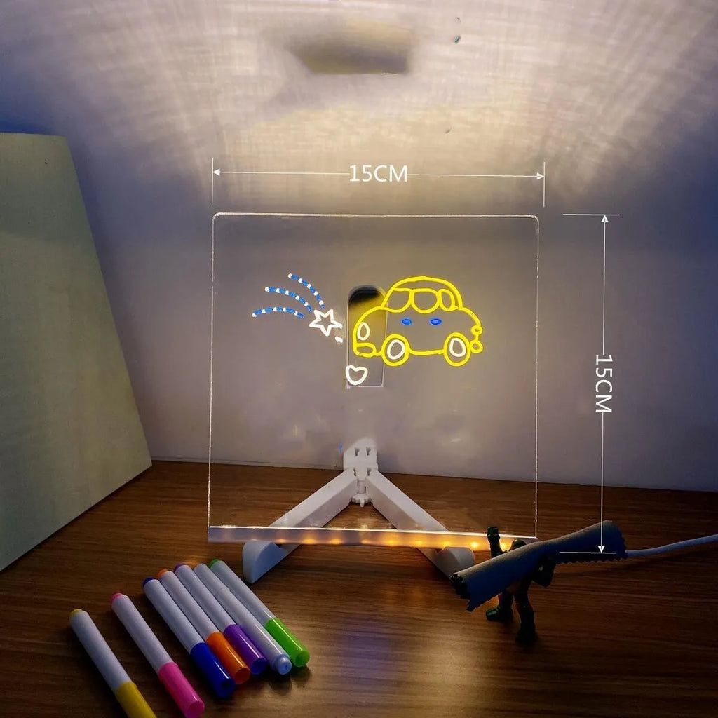 DIY acrylic LED message board lamp on a desk with colourful writing, showing USB cable and pens.