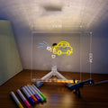 DIY acrylic LED message board lamp on a desk with colourful writing, showing USB cable and pens.