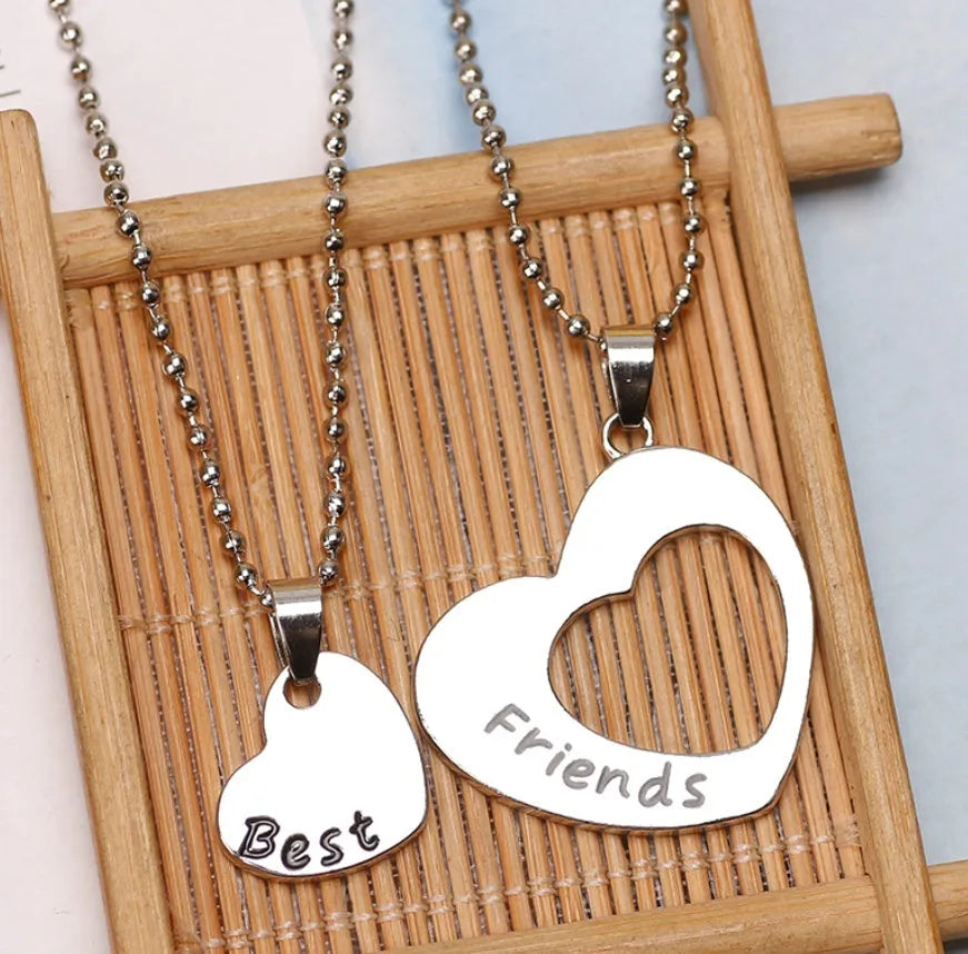 Two silver alloy heart-shaped puzzle necklaces on cross chains, matching set