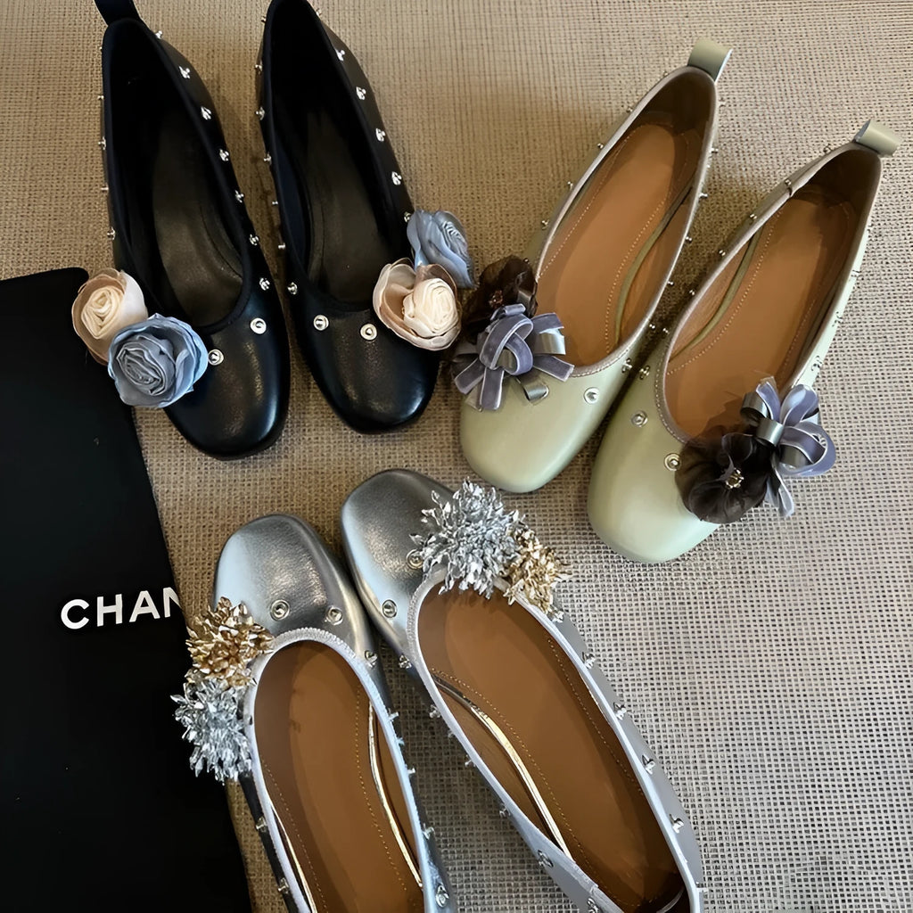 Women's silver Mary Jane flat shoes with flower rivets and a buckle strap on a sheepskin upper.