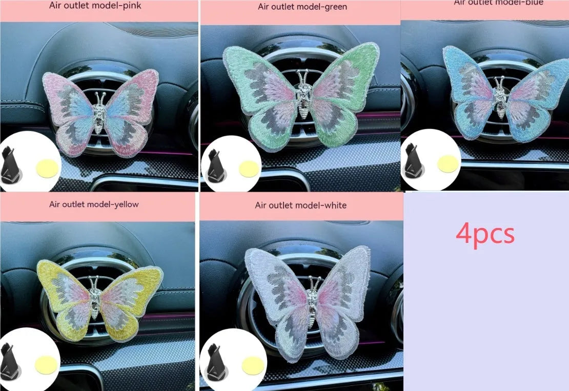Fabric embroidered butterfly car air vent decoration in multiple colour options on a dashboard.