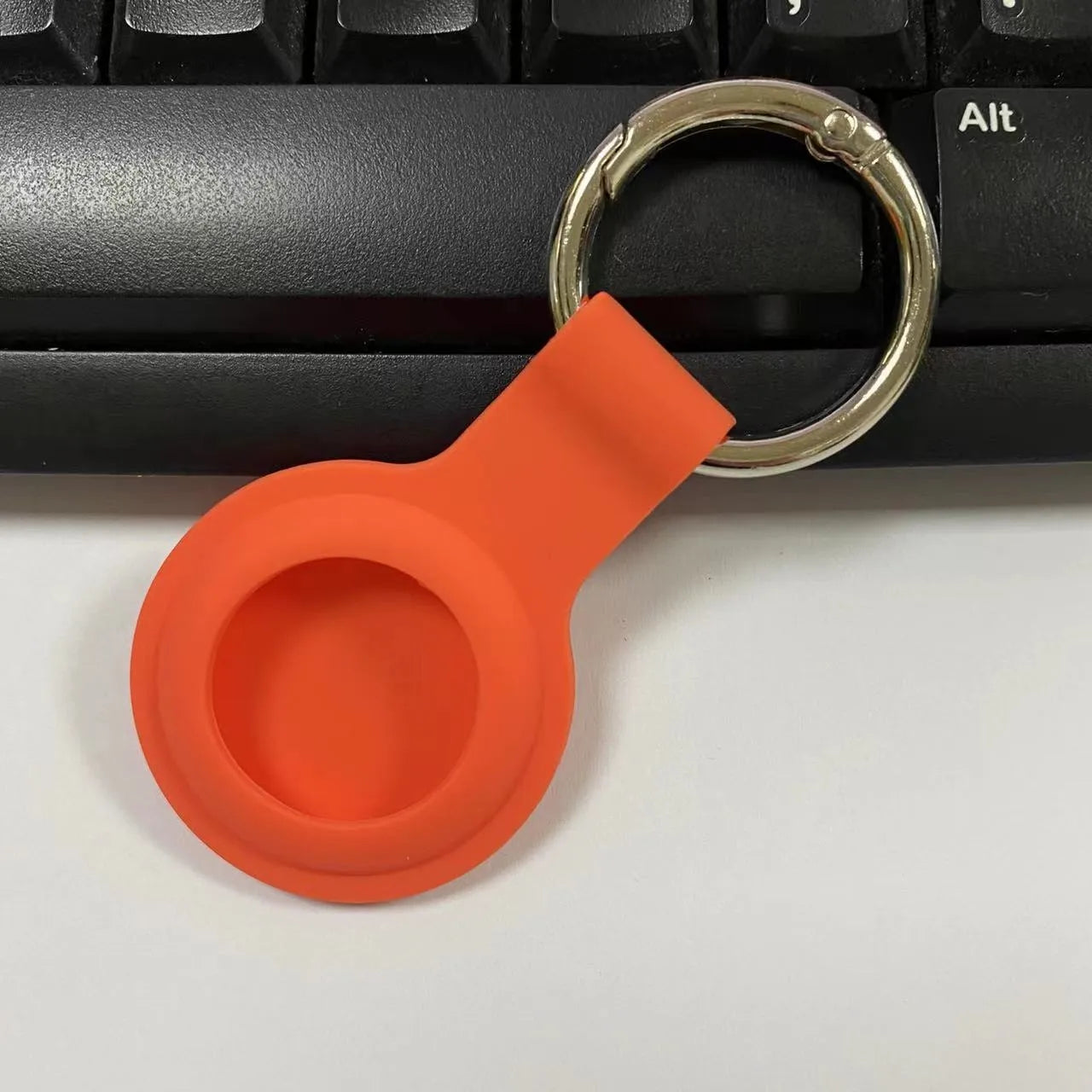 Silicone protective case with metal keychain snap for Apple AirTag in multiple colours.