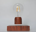 Magnetic levitation light bulb floating above its imitation wood base.