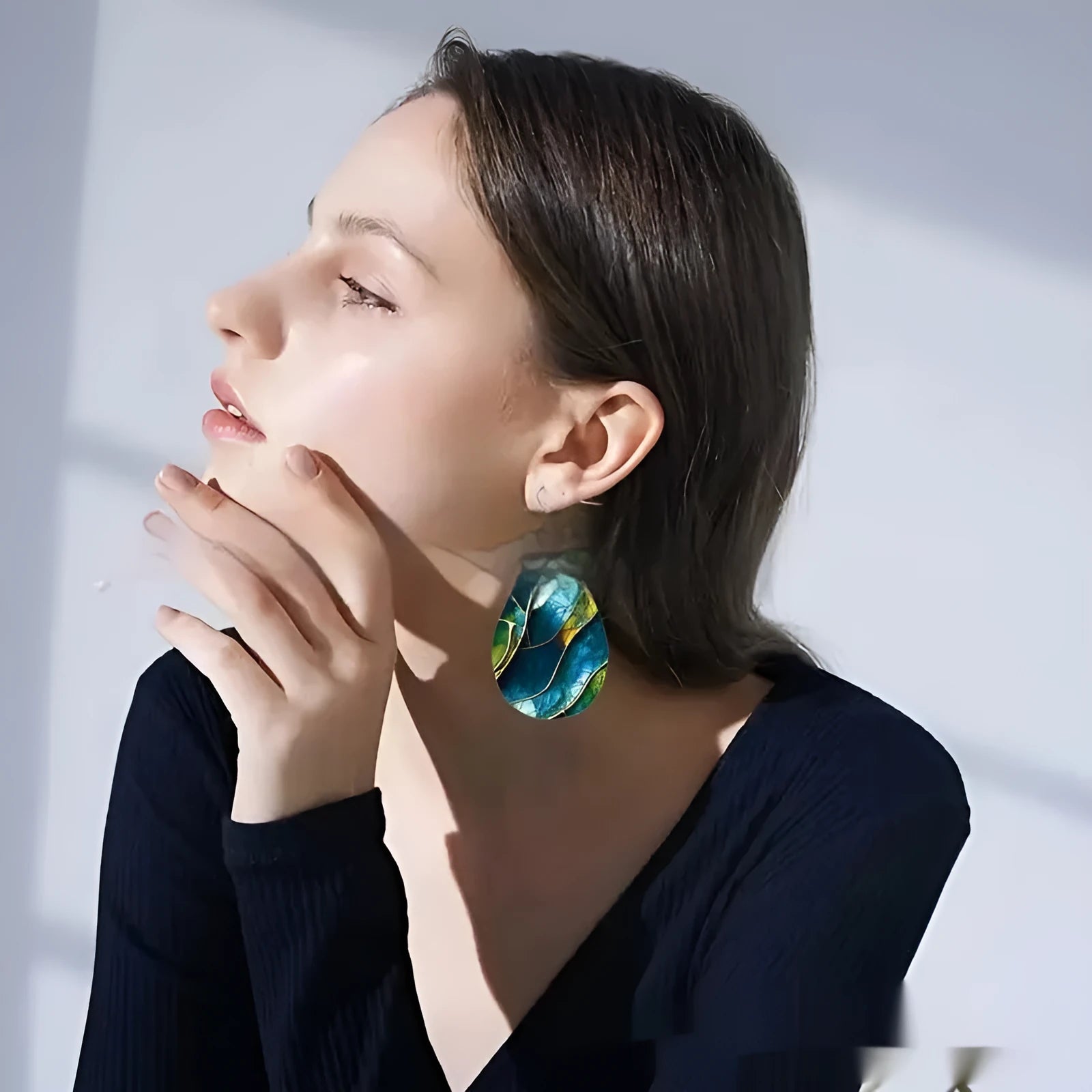 A pair of printed acrylic drop earrings with a flat branch knot design.