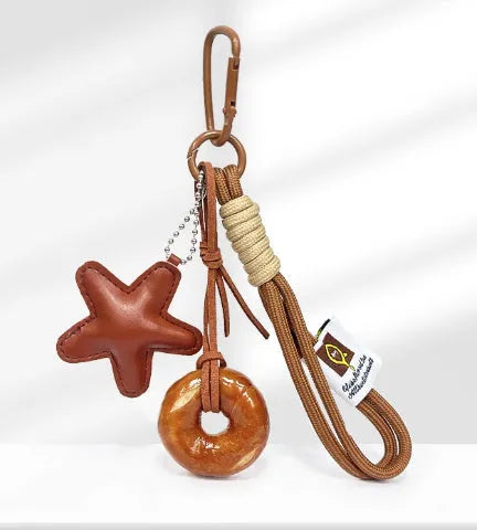 Handmade resin soda bread handbag pendant with baking varnish finish and brown carrying strap.