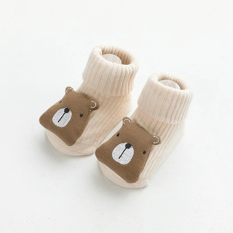 Baby socks with non-slip rubber grip soles on the feet, shown in a light grey colour.