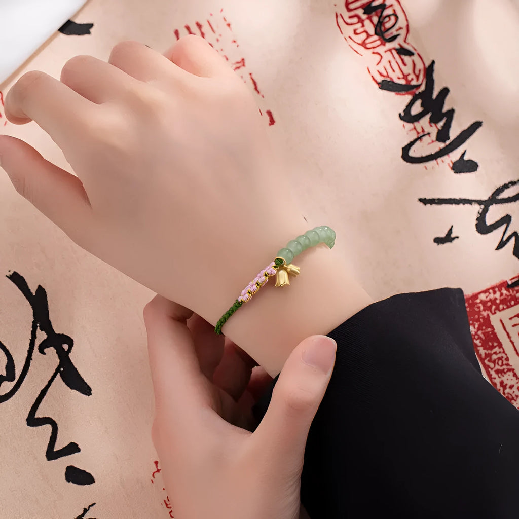 Hand woven red rope bracelet with floral decorative elements in national style design