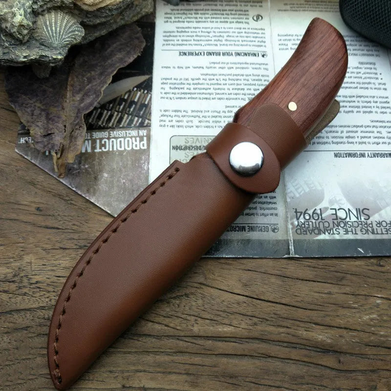 Outdoor survival knife with brown mahogany handle and 8cm stainless steel blade on wooden surface