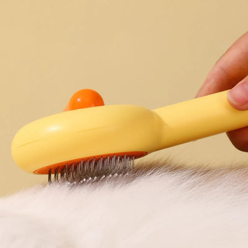 Small yellow duck-shaped pet grooming comb with open-section needle brush design for cat and dog hair removal