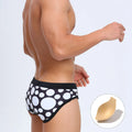 Men's triangle printed swimming trunks with cups, black ribbon cup design, polyester fabric, front view