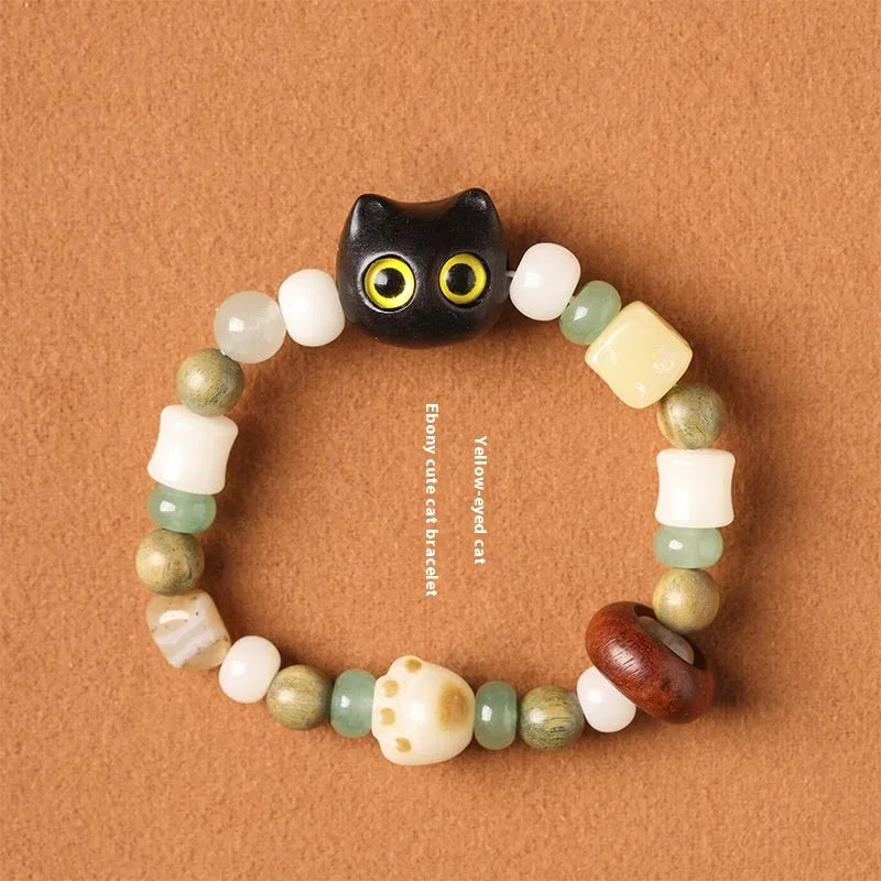 Hand-woven multi-treasure bracelet with Bodhi seeds, jade, and wood beads featuring a cat's paw charm.