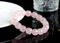 Close-up of a pink geometric bracelet with barrel-shaped crystal beads on a wrist.
