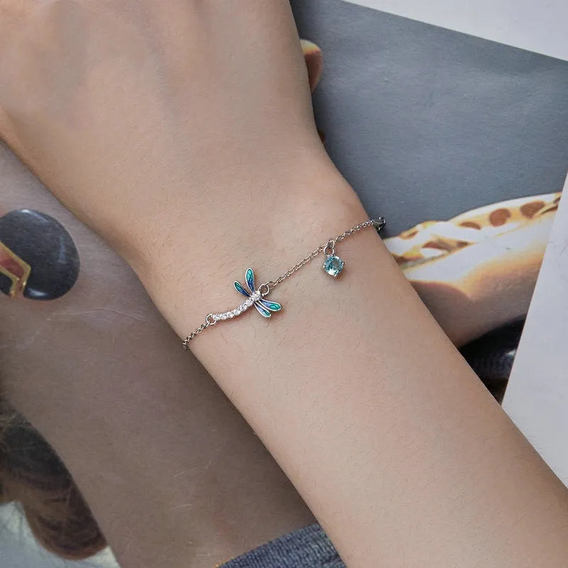 Sterling silver white gold plated dragonfly bracelet with dripping zircon stones on white background