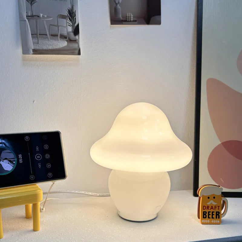 Glass mushroom decorative lamp with three-colour light in orange smooth finish on a wooden table