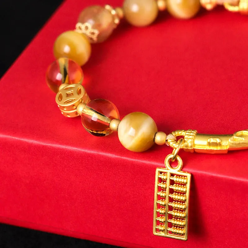 Women's beaded bracelet with tigereye, citrine, and yellow tower crystal beads in a diamond pattern.