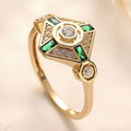 Square-shaped gold tone ring with emerald diamond colour on a model finger.