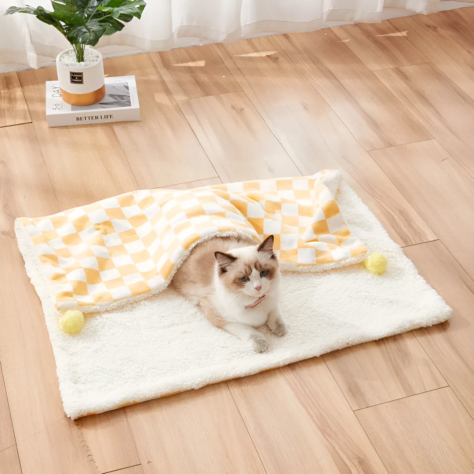 Soft plaid pattern pet blanket with fur ball decoration on a sofa