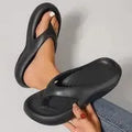 A pair of women's thick-soled flip-flops in grey, showing the EVA material and non-slip footbed texture.