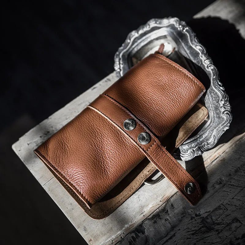 Handmade dark brown cow leather vintage bifold wallet with tape extraction closure, shown open.