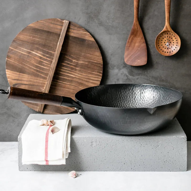 Black traditional iron wok pan with wooden handle, 32cm diameter with matching lid.
