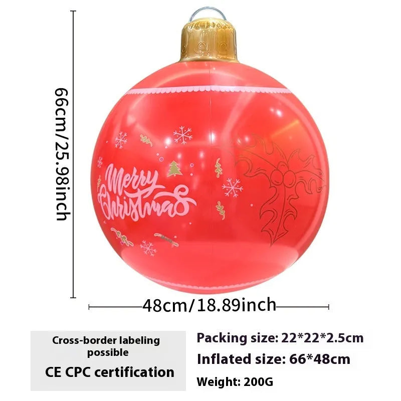 Large red inflatable Christmas ball with flashing lights displayed on a winter garden lawn.