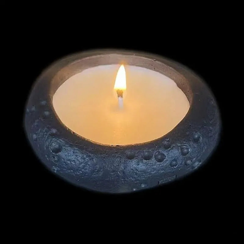 White concrete candle holder on a flat surface with a tea light inside