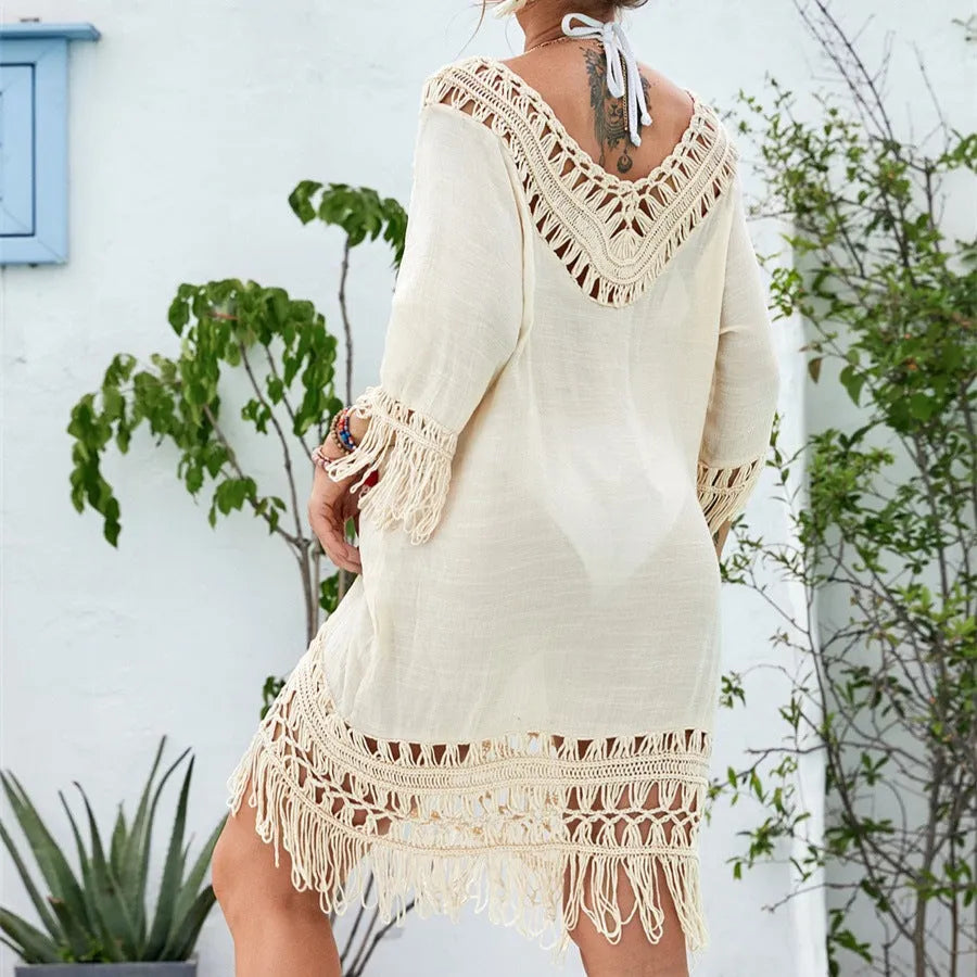 Apricot crocheted patchwork beach dress on a hanger showing textured knit and mid-length skirt.