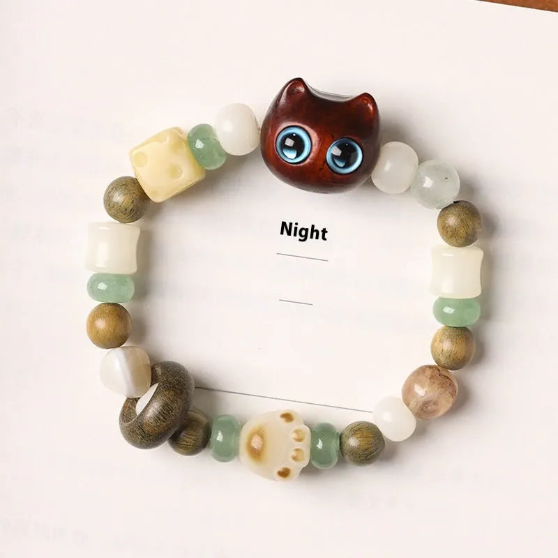 Hand-woven multi-treasure bracelet with Bodhi seeds, jade, and wood beads featuring a cat's paw charm.