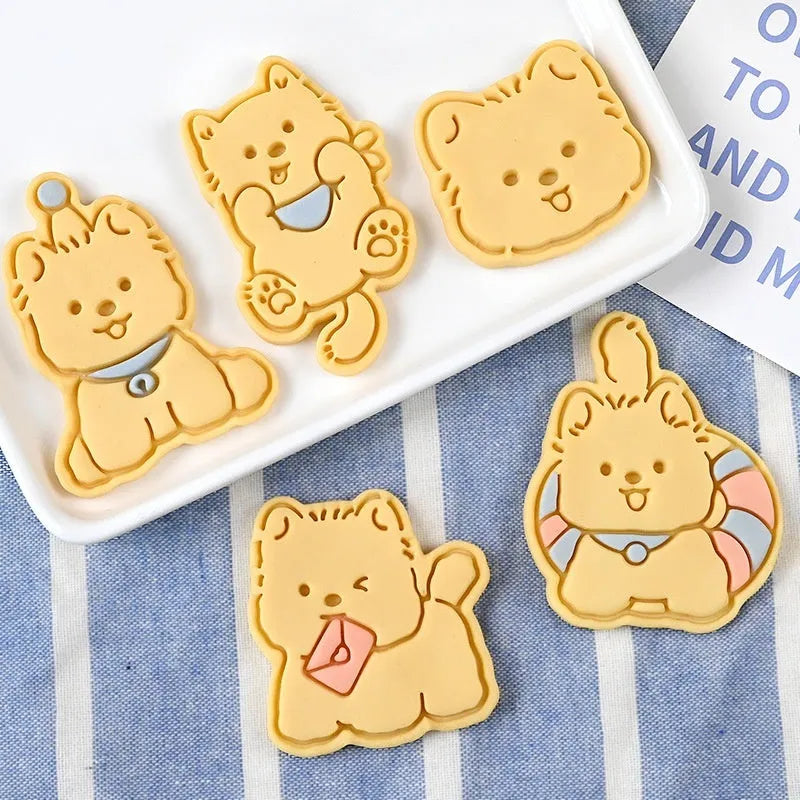 A 3D plastic biscuit mould showing raised puppy head, birthday hat, and dog cartoon designs.