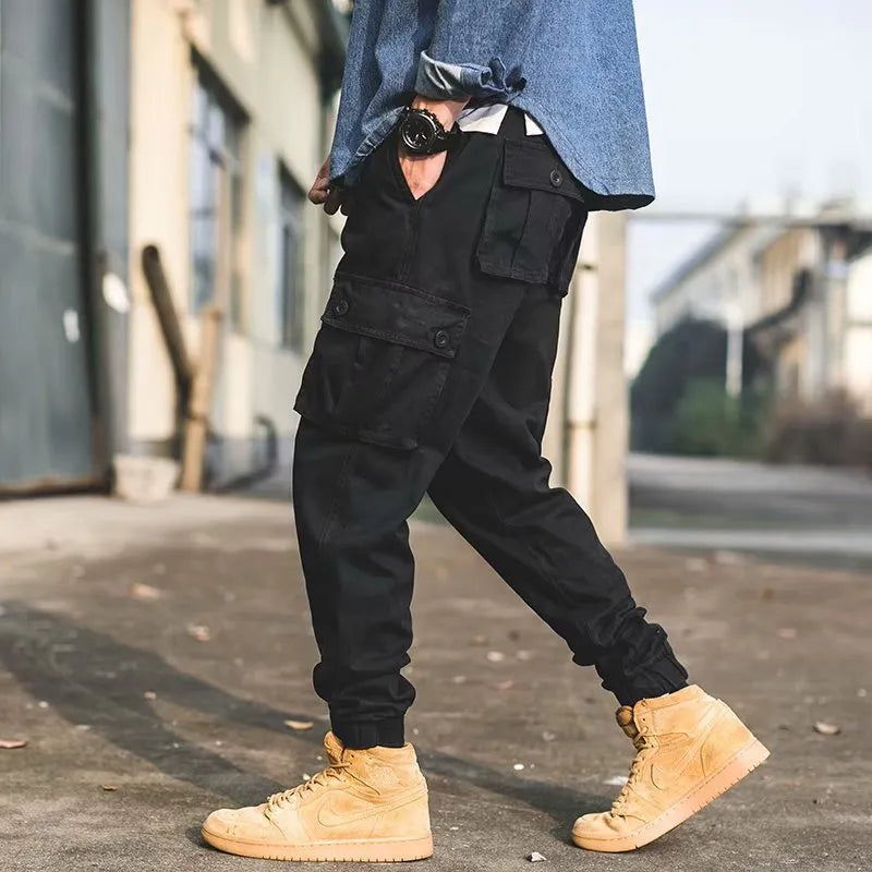 Men's black cotton overalls with loose cropped fit, ankle banded hem, and multiple pockets