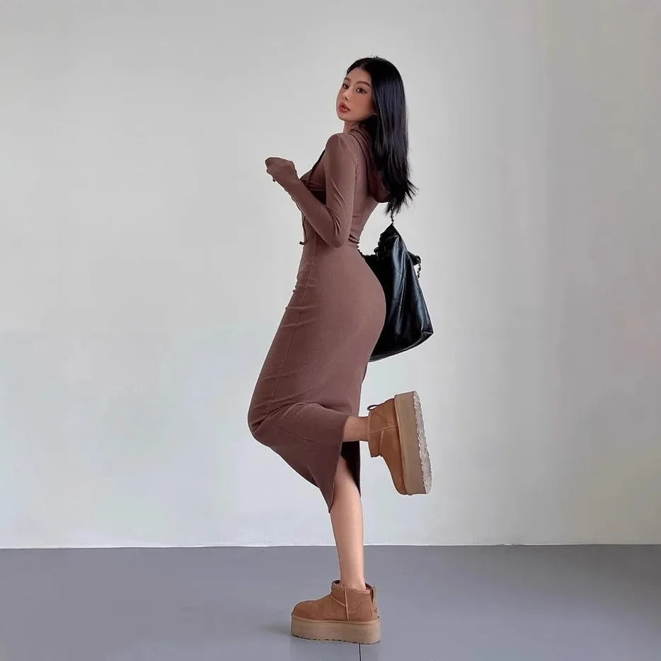 A woman's light grey hooded sheath dress with long sleeves, high waist, and over-the-knee length.