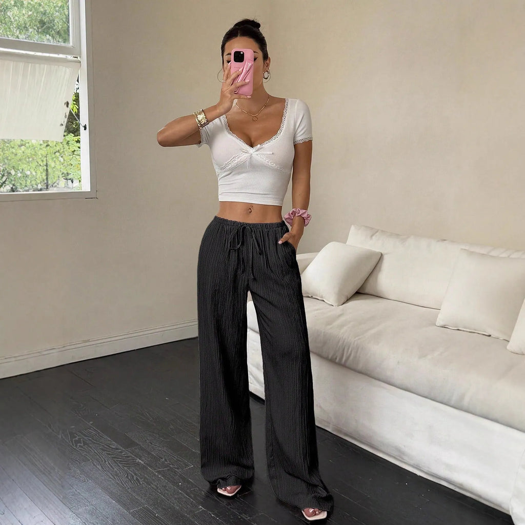 Women's black wide leg trousers with a front lace-up detail on the mid waist.