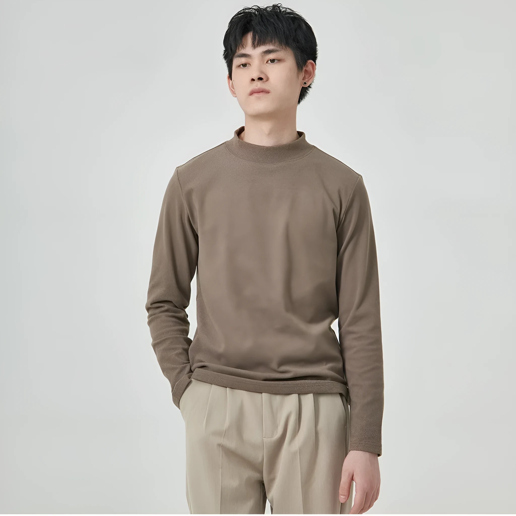 Men's brown Dralon fabric long sleeve t-shirt with a half-high collar on a hanger.