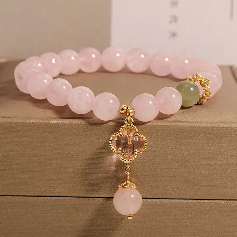 Pink crystal bracelet for women with a four-leaf clover pendant and sparkling rhinestones.