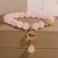 Pink crystal bracelet for women with a four-leaf clover pendant and sparkling rhinestones.